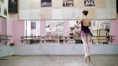 在舞厅里，穿着黑色紧身衣的年轻芭蕾舞演员表演<strong>巡回</strong>赛，她优雅地穿过芭蕾舞班，